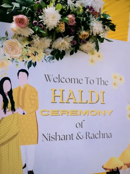 A personalized welcome sign for a Haldi ceremony, featuring a cute caricature of the couple, Nishant and Rachna.
