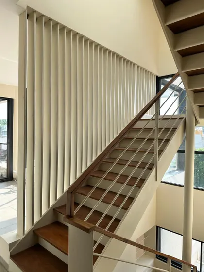 A vertical screen of metal fins provides safety along the staircase while creating an interesting textural element.