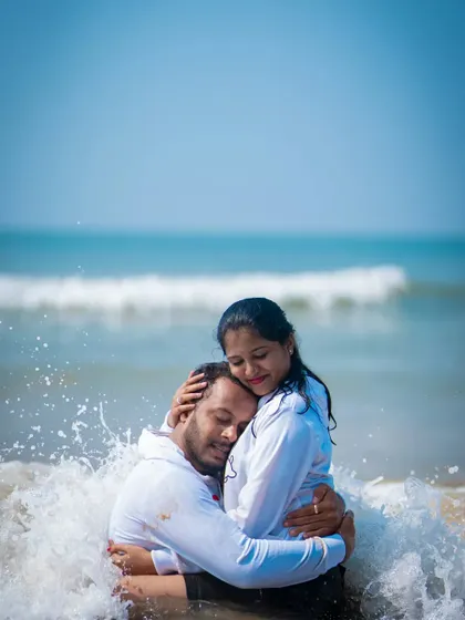 A fun and spontaneous moment of a couple embracing in the ocean waves during their pre-wedding shoot.