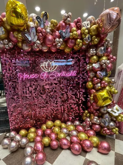 This shot captures the full balloon frame around the custom neon sign and shimmer wall.