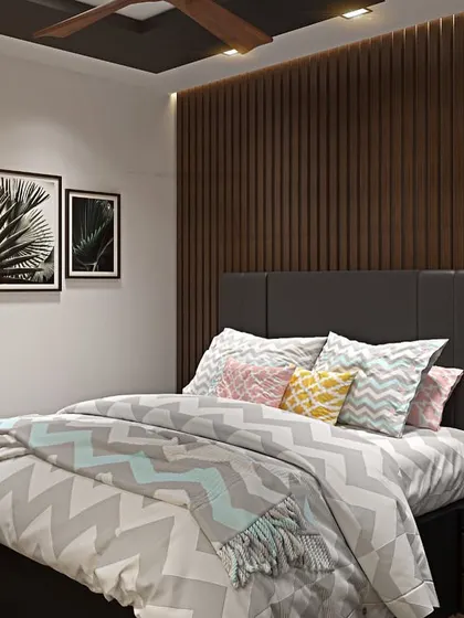 This bedroom design uses a dark wood-paneled accent wall to create a warm and cozy atmosphere. The chevron-patterned bedding and framed art add texture and personality to the space.