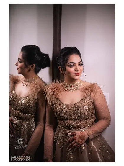 Reshma's glamorous cocktail party look. The makeup is more defined for the evening, with a smokey eye and contoured features that pair beautifully with her feathered gold gown.