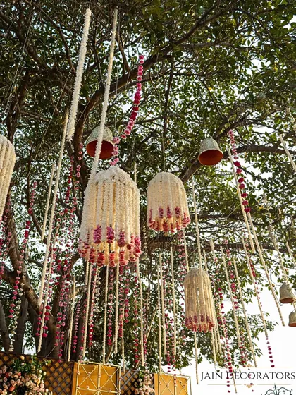 A whimsical detail hanging from the trees. These beautiful floral chandeliers, made from jasmine and roses, add a touch of magic and fragrance to the outdoor setting.