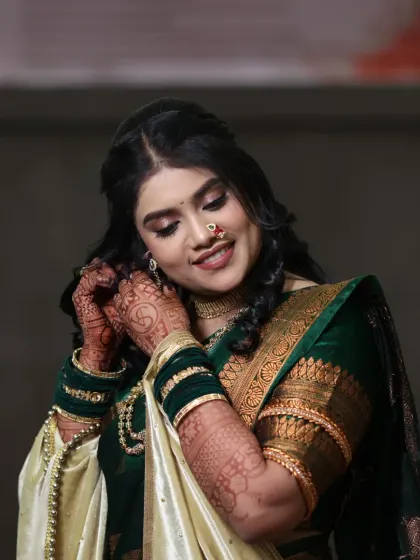 A beautiful bride getting ready for her sakarpuda. This candid moment shows her adjusting her earring, with her soft makeup and hairstyle looking perfect.