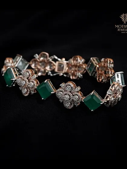 An opulent bracelet featuring square-cut emeralds and floral diamond clusters. This is a truly luxurious piece that combines classic gemstones with intricate design.