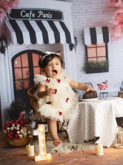 A moment of pure excitement. This little one can't wait to dig into her first birthday cake.