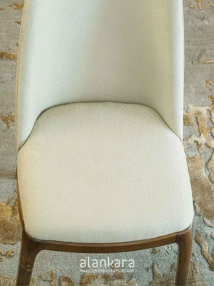 A top-down detail of the White Arber chair's seat, showing the quality of the fabric weave and the precision of the upholstery work.