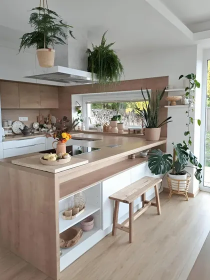 For those who love greenery, this kitchen brings the outdoors in. The large wooden island provides space for cooking and seating, while ample natural light and numerous plants create a fresh, biophilic-inspired environment.
