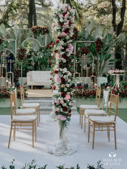 A stunning floral arrangement at a Nikah ceremony. The tall pillar of red and white roses makes a dramatic and beautiful statement on the main stage.