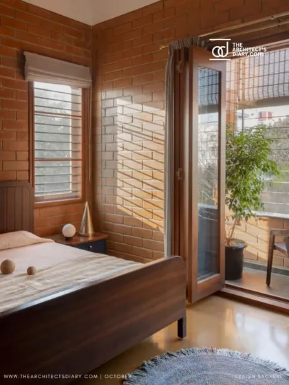 Another view of the sunlit bedroom, showing how the light plays on the natural brick texture, creating a warm and inviting atmosphere.
