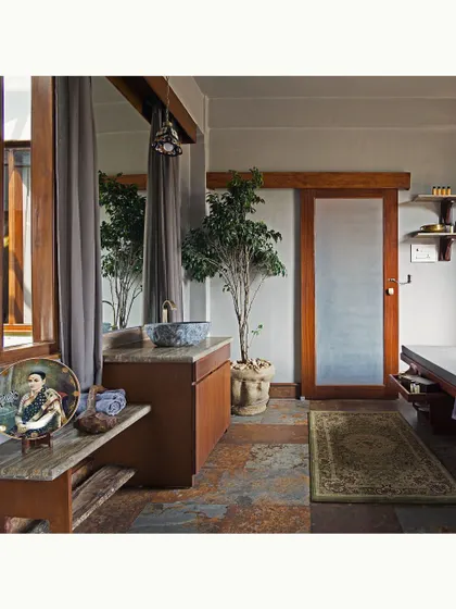 The bathroom and massage room combines functionality with rustic elegance. I used local stone for the flooring and countertops, paired with wooden cabinetry and a sliding door to create a space that feels both earthy and refined.