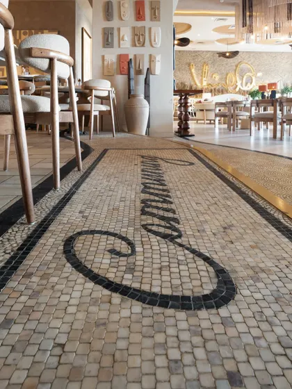 Detail is everything. This custom mosaic floor at One 8 Commune was handcrafted by my artisans, piece by piece. The design, which spells out "Communing," serves as a signature art piece that grounds the space and immediately communicates the restaurant's brand and welcoming vibe. It’s a perfect example of how flooring can be foundational art.