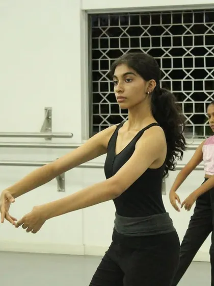 A close-up on a student's focused expression during a contemporary dance session. The mental concentration required is just as important as the physical effort.