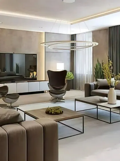 A spacious and luxurious living room with a neutral color palette. The design includes multiple seating options and a large TV unit, making it ideal for both relaxation and entertaining.