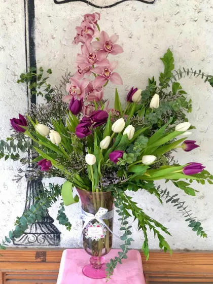 A classic vase arrangement featuring a beautiful mix of purple and white tulips, pink cymbidium orchids, and fresh eucalyptus. This is a perfect example of the elegant floral bouquets I create for gifting or home decor.