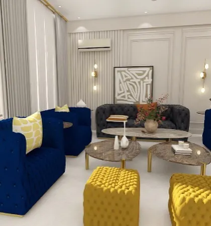 Another seating area in Villa 72, with tufted royal blue sofas and mustard yellow ottomans. The design uses wall moldings and modern art to create a sophisticated, gallery-like feel.