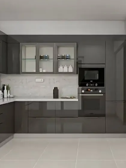 A luxurious L-shaped kitchen with dark grey high-gloss cabinets. This design features frosted glass doors on some upper cabinets, integrated appliances, and a clean white countertop, perfect for a modern and stylish home.