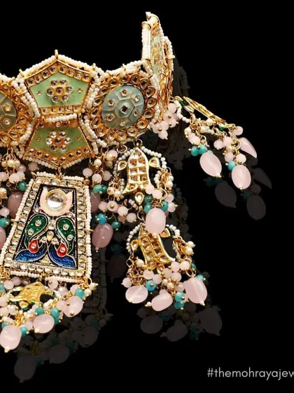 A close-up of a unique choker with pastel green and pink meenakari work. This handcrafted piece is perfect for a bride looking for something truly special.