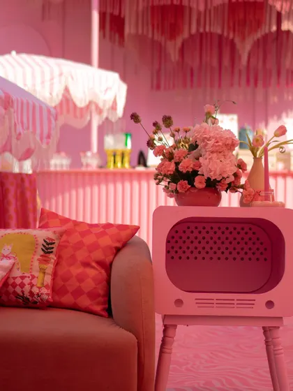 A retro-style TV prop painted pink served as a unique floral stand, adding to the fun and quirky "Barbie World" theme.