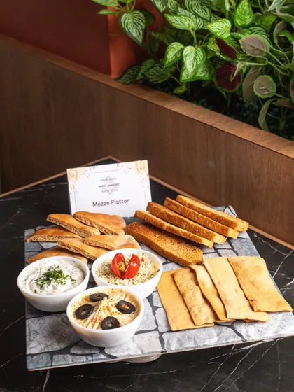 Our Mezze Platter is perfect for sharing and socializing. It features a variety of dips like hummus and tzatziki, served with an assortment of pita bread and crisps.