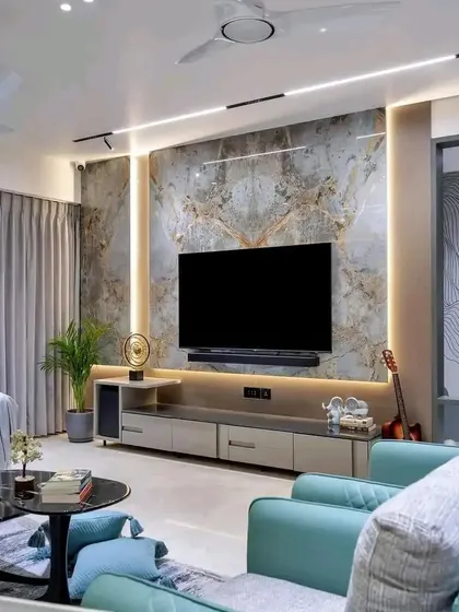 The TV unit area in the same 2BHK. It features a large marble-finish panel, track lighting, and a sleek, low-profile console.