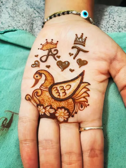 A cute and personalized design with a swan, hearts, and the initials 'A' and 'T' with crowns. I can create any custom motif you have in mind.
