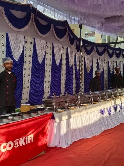 Our team ready for a large housewarming event with an extensive buffet line set against a beautifully decorated backdrop.