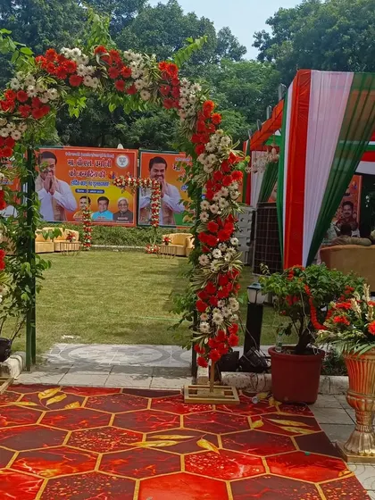 Here is another view of the floral entrance arch I created for a political event. The combination of red and white flowers, green foliage, and the tricolor tent in the background showcases a complete, themed decoration package.