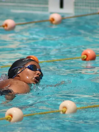A close-up of a swimmer practicing their freestyle stroke, showing focus and determination.