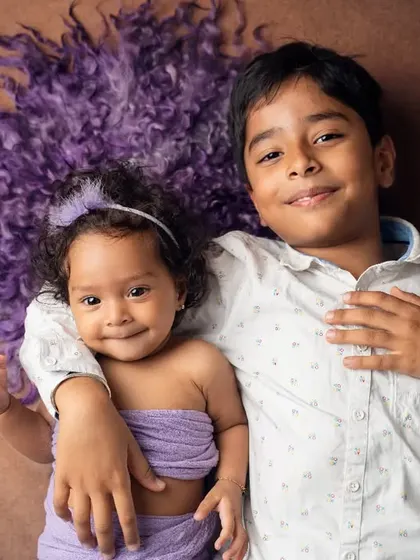 An adorable overhead shot of a brother and sister. We use creative angles and cozy props to create unique and heartwarming sibling portraits that show their special bond.