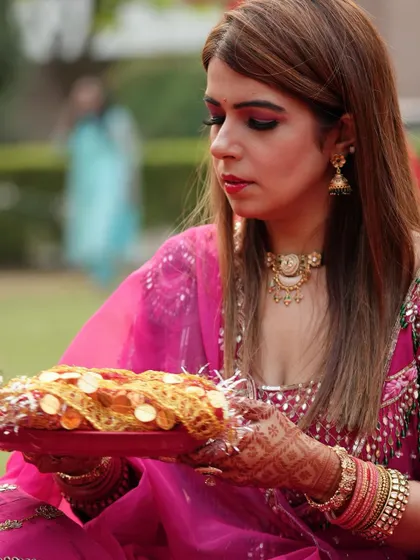 Here you can see a close-up of the client's hands and the puja thali, with the detailed mehendi adding to the beauty of the moment.