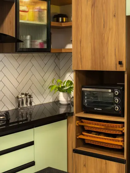 A detail shot showing the integrated appliance garage for the microwave and oven, along with pull-out trays. Every inch is planned for maximum utility and ergonomic ease.