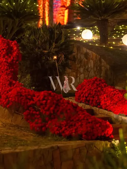 A path paved with passion. I used large, sculptural arrangements of red flowers to line the walkway, creating a dramatic and romantic entrance for the event.