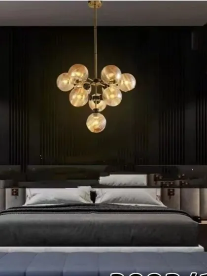 This gold globe chandelier adds a touch of luxury to a modern bedroom. The cluster of smoked glass globes provides a warm, intimate light that enhances the room's sophisticated design.