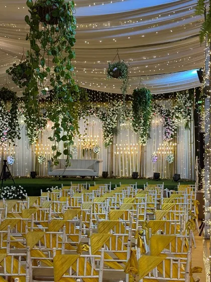 A magical wedding setup on the Sky Terrace, with glittering confetti on the aisle, hanging floral arrangements, and a stunning stage design.
