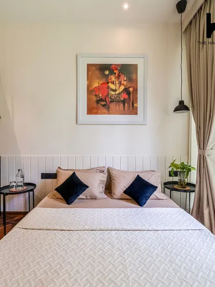 The bedroom area is designed to be a peaceful sanctuary, with tasteful art, comfortable bedding, and easy access to the kitchenette and storage.