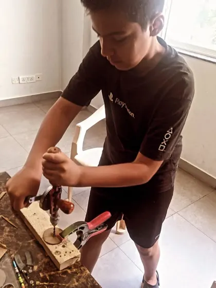 This student shows great form while using a hand drill, a skill that is useful across many engineering and DIY projects.