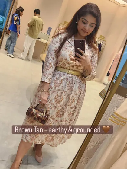 An earthy and grounded look with a brown tan bag that echoes the colors in the printed outfit.