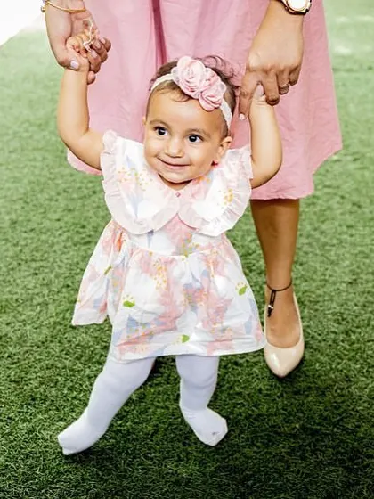 Taking those first wobbly steps with mom's help. Capturing milestones like learning to walk is a wonderful way to document your baby's development.
