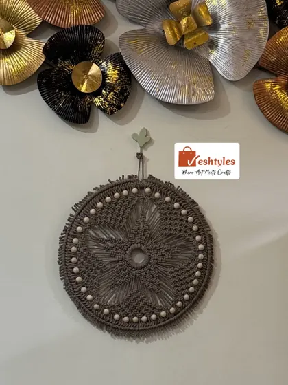 Here is my star-patterned macrame wall hanging, shown against a wall with other decor. Its round shape and detailed knotwork make it a versatile piece that can stand alone or complement other art.