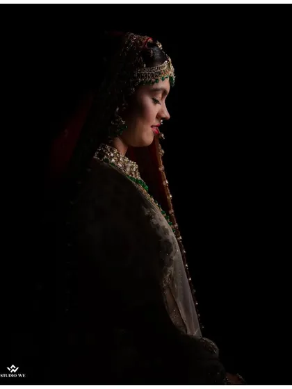 A moody and artistic portrait of the bride, her face partially obscured by darkness, creating a sense of mystery and elegance.