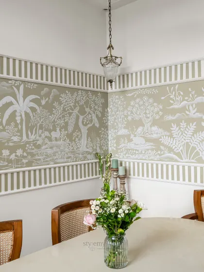 A corner view of the hand-painted Rajasthani mural in the 'Sushobit' dining room. The soft hues and striped border create a perfect harmony of heritage and contemporary charm.