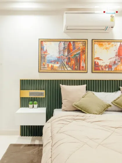 A close-up of a bedroom design where a green fluted headboard is paired with bright, expressive artwork, creating a beautiful contrast that adds personality to the space.