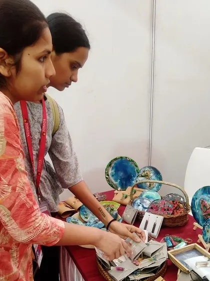 Customers browsing the items at my pop up stall. It is always rewarding to see people connect with my work, taking the time to examine the details of each handmade piece.