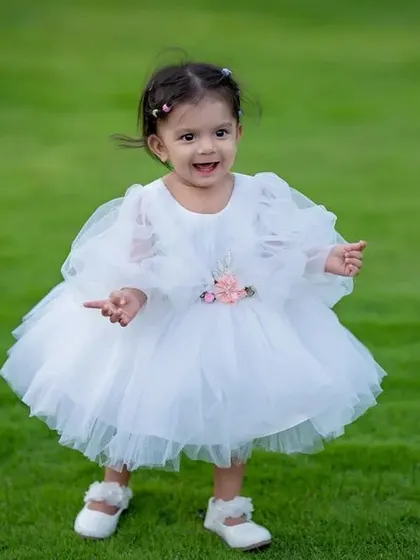 Little hands, little feet, pure joy. A simple white dress and green grass create a fairytale feel.