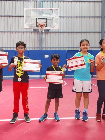 Young players proudly displaying their certificates and medals on our professional court after a tournament.