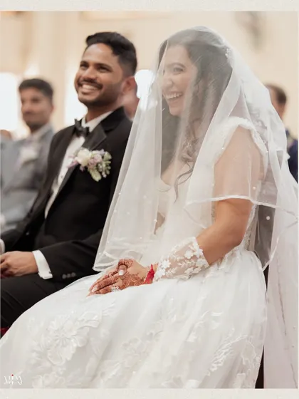 A candid shot of the bride and groom sharing a laugh during their church ceremony.