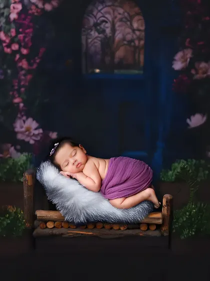 A fairytale-like scene with a baby sleeping on a rustic wooden bed in an enchanted forest setting. This shows the creative backdrops I can use to bring a theme to life.