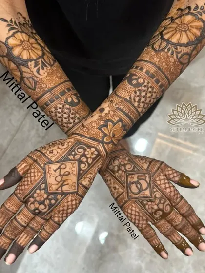 A full view of an engagement design, with the couple's initials and ring symbols set in a diamond-shaped frame, surrounded by floral and geometric patterns.
