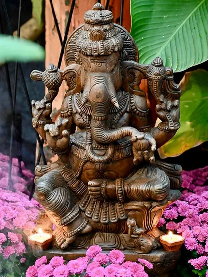 A beautifully detailed Ganesha statue sits amidst a bed of flowers and glowing diyas, capturing the essence of Diwali celebrations.